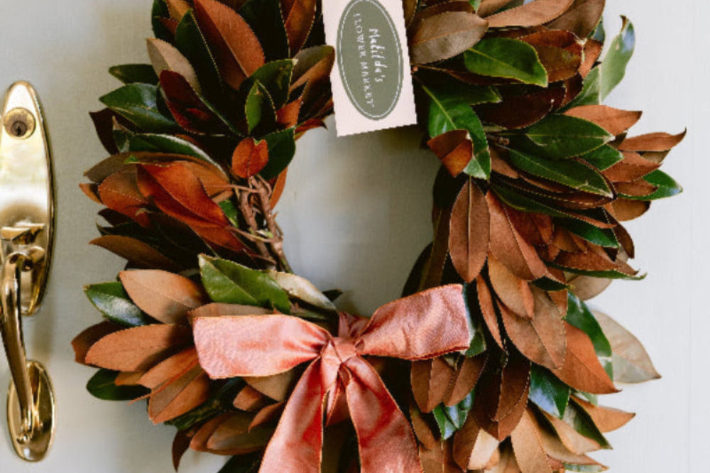 Magnolia wreath with satin ribbon bow, handcrafted in California by Matilda’s Flower Market and delivered nationwide.