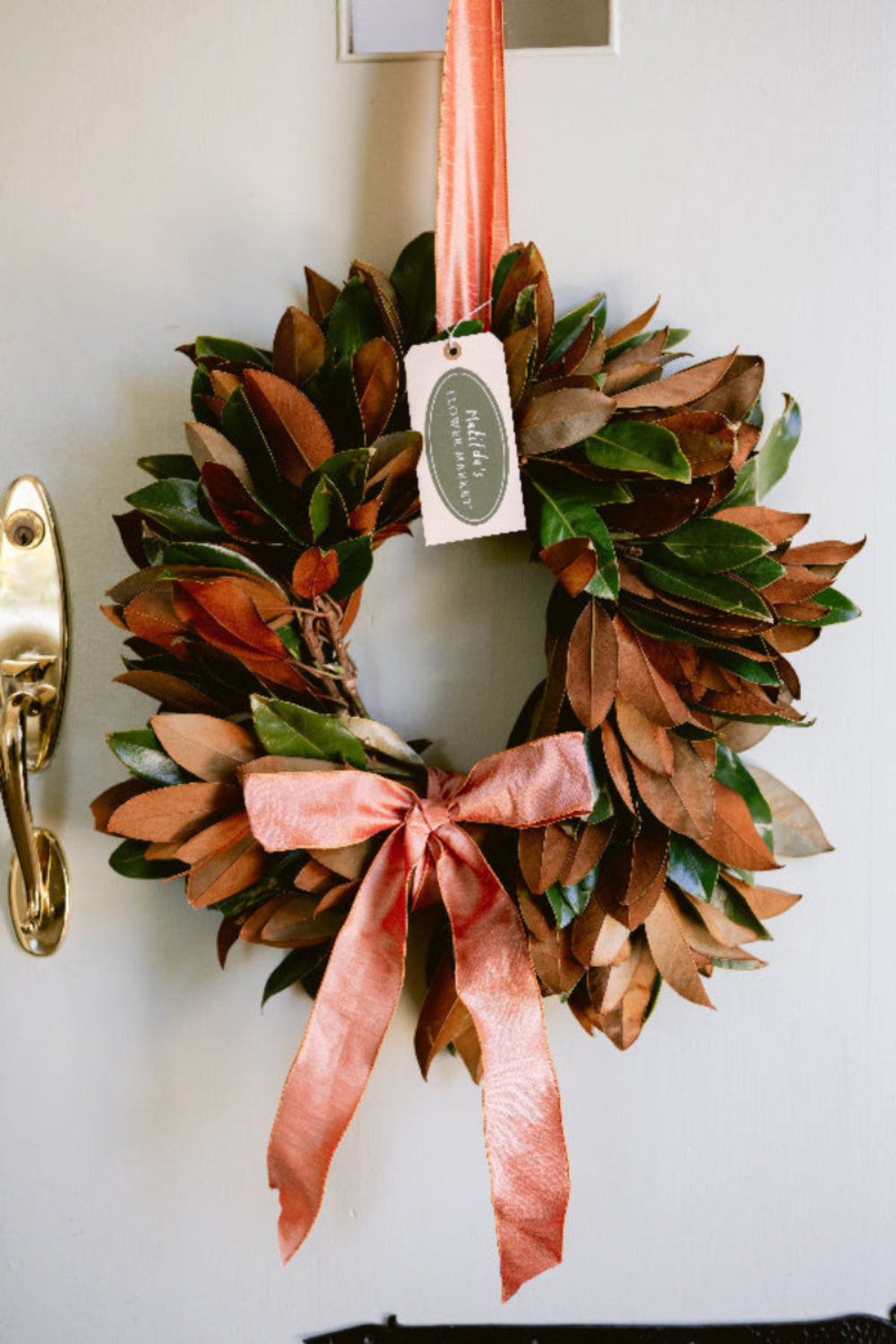 Magnolia wreath with satin ribbon bow, handcrafted in California by Matilda’s Flower Market and delivered nationwide.